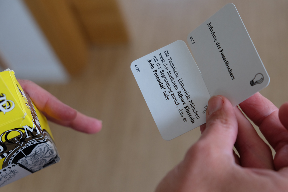 Karte in der Hand, die erzählt, dass Albert Einstein einst von der Technischen Universität München zurückgewiesen wurde, weil er kein Potential habe.