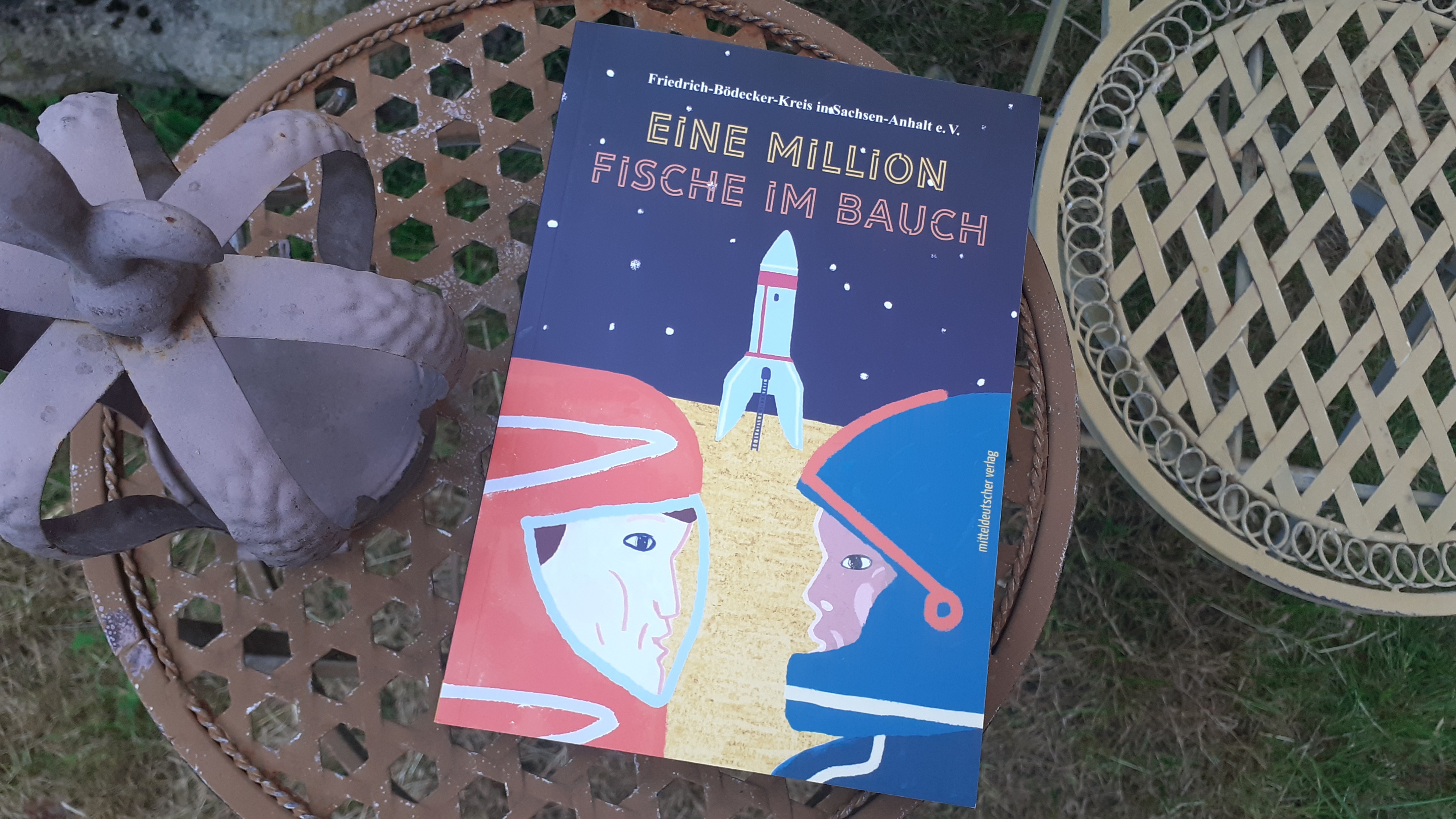 Cover der Anthologie Eine Million Fische im Bauch: Zwei Astronaute blicken sich an, zwischen ihnen zündet eine Rakete.
