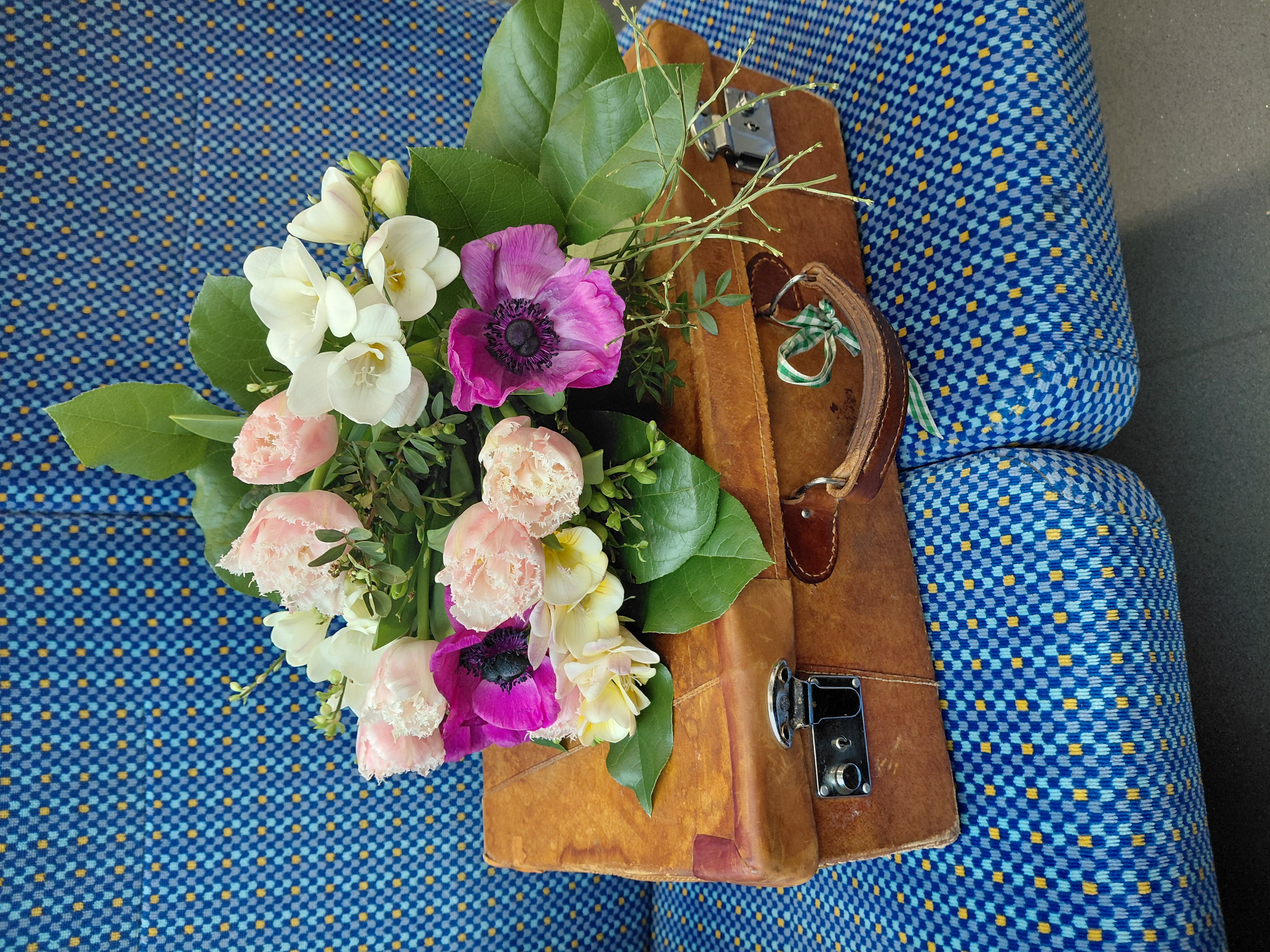 Blumenstrauß auf Leseköfferchen in der U-Bahn